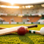 Quel sport faut-il vraiment citer comme sport national indien ? Composition sportive sur une pelouse indienne présentant une batte de cricket, une balle rouge, une crosse de hockey sur gazon et une balle blanche, éclairées par une lumière dorée.